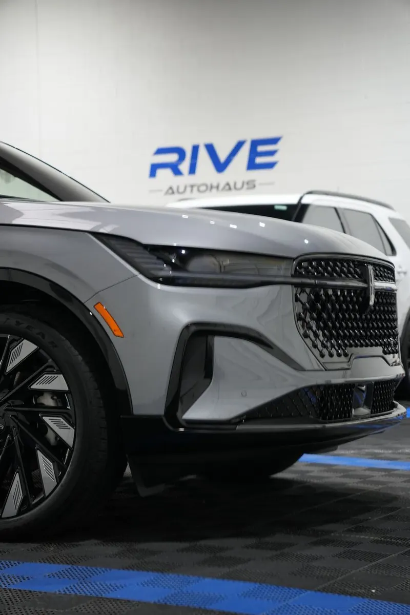 Front quarter view of a vehicle in a shop bay, with 'Rive Autohaus' lettering visible on the wall.